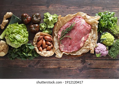 Uncooked Flank Steak With Seasonal Vegetables. Raw Beef Meat And Healthy Cooking Ingredients.  Dark Wooden Background, Copy Space