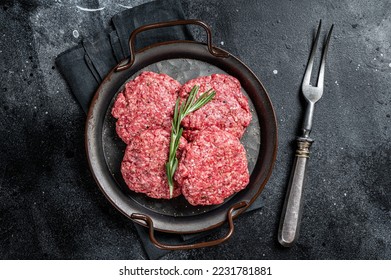 Uncooked Frikadellen from Mince beef Meat, raw meat cutlets. Black background. Top view. - Shutterstock ID 2231781881