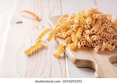 Uncooked Fusilli Pasta Scattered on Wooden Board