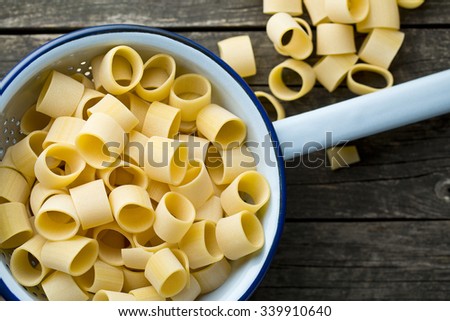 uncooked pasta calamarata in colander