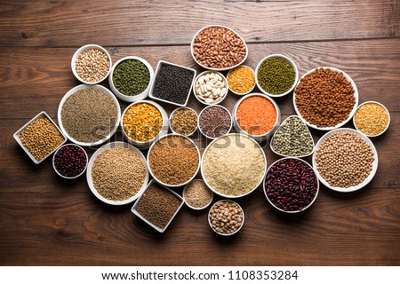 Uncooked pulses,grains and seeds in White bowls over wooden background. selective focus
