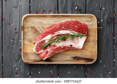 Uncooked raw beef brisket on wooden board