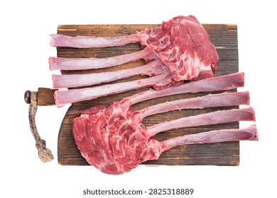Uncooked raw lamb rack bone ribs in meat arranged on wooden cutting board isolated on white background culinary ingredient.