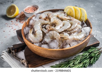 Uncooked Raw peeled tiger white shrimp prawn. Gray background. Top view.