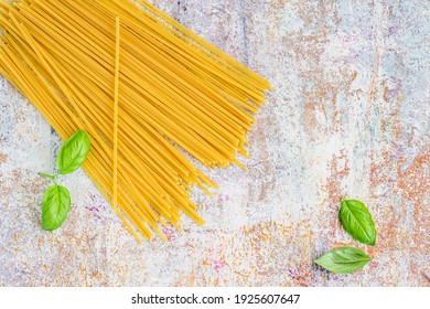 Uncooked Raw Spaghetti Pasta With Fresh Basil Leaves Top Down Food Background Photo