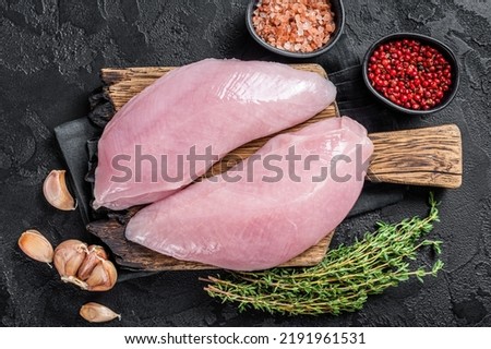 Uncooked Raw Turkey Breasts fillet steaks with herbs. Black background. Top view. Сток-фото © 