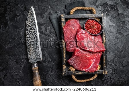 Uncooked Raw Venison dear meat, game meat. Black background. Top view.