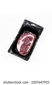 Uncooked Ribeye Steak In Vacuum Pack On White. Raw Fatty Beef Steak.