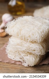 Uncooked Rice Noodles On Wooden Table, Closeup