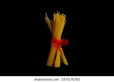 Uncooked spaghetti tied with red ribbon - Powered by Shutterstock