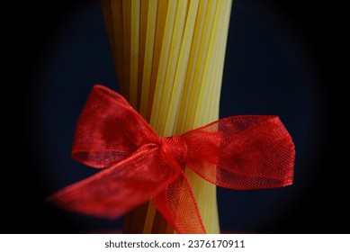 Uncooked spaghetti tied with red ribbon - Powered by Shutterstock