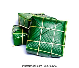 Uncooked Vietnamese Chung Cake isolated on white. It??s a square glutinous sticky rice cake, stuffed with pork meat, green beans and wrapped in bamboo leaf. Traditional Vietnamese New Year (Tet) food.