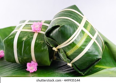 Uncooked Vietnamese Chung Cake isolated on white. It's a square glutinous sticky rice cake, stuffed with pork meat, green beans and wrapped in bamboo leaf. Traditional Vietnamese New Year (Tet) food.