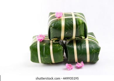 Uncooked Vietnamese Chung Cake isolated on white. It's a square glutinous sticky rice cake, stuffed with pork meat, green beans and wrapped in bamboo leaf. Traditional Vietnamese New Year (Tet) food.