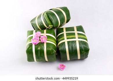 Uncooked Vietnamese Chung Cake isolated on white. It's a square glutinous sticky rice cake, stuffed with pork meat, green beans and wrapped in bamboo leaf. Traditional Vietnamese New Year (Tet) food.