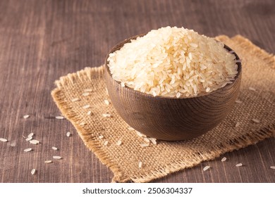 Uncooked white rice in a wooden bowl. Healthy cereal concept.  