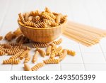 Uncooked whole grain pasta. Raw fusilli in a bowl.