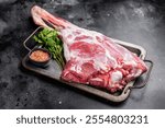 Uncooked whole mutton leg, raw organic lamb meat. black background. top view.