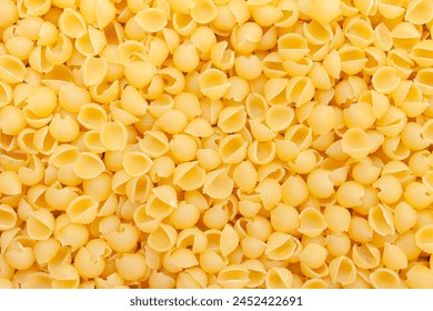 Uncooked, yellow shell pasta background. Top view - Powered by Shutterstock