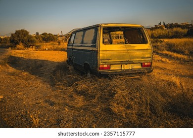 Uncover the poignant tale of abandonment as the golden hour illuminates a forsaken green Volkswagen Transporter, nestled among the grasses on the roadside of Crete, a time-tinged memory frozen in time - Powered by Shutterstock