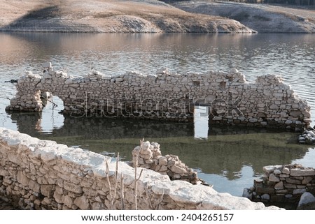 Uncovered ruins of the former village of 'Sant Romà de Sau' - due to the extreme drought the water level of the Sau reservoir is very low - picture taken in November 2023