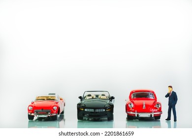 Undecided Car Shopper Deciding On A Classic Toy Cars, Miniature Figures Scene, White Background