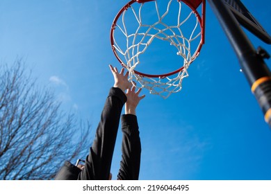 Under The Basketball Hoop With Child's Hands Reaching Up