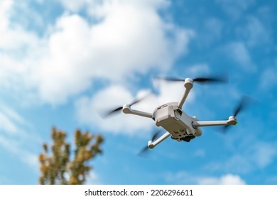Under belly of an intelligent drone seeing flying towards to clouds. The for rooters and downward collision sensors are seen.
