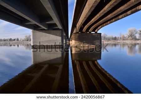 Under  the bridge symmetrical blue winter landscape 