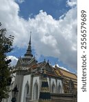 Under a bright sun, Bangkok’s colorful temples gleam with intricate mosaics and golden spires, their vibrant hues standing out against the clear blue sky.