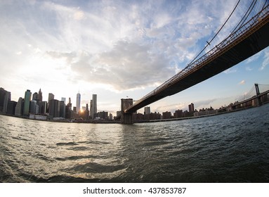 Under the Brooklyn Bridge while sunset over Manhatten New York C