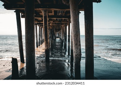 Under a California pier with calm sea. - Powered by Shutterstock
