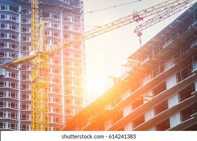 Under Construction High-rise Building With Yellow Construction Crane In The Sunlight