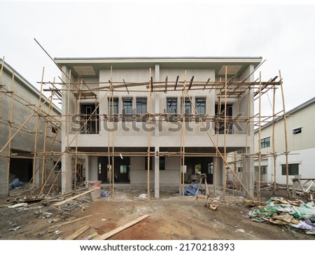 Under construction home or house with scaffolding on site in village. Old unfurnished rental property, living space units. lifestyle. Renovation.