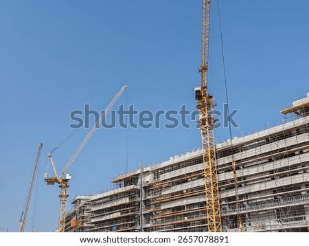 Under construction residential building with Concreate Block structure and Fixed Tower Crane.
Exterior viewHighrise Multistory building modern design,
Yellow Fixed Tower Crane and erected Scaffolding.