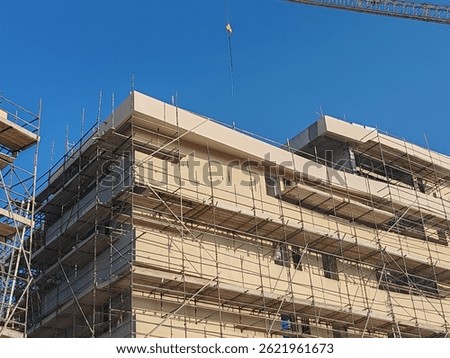 Under construction residential building structure
Highrise Skyscraper Exterior Modern Design Top Level View with blue sky background
Multi Storey Residential Building Site erected Scaffolding Around