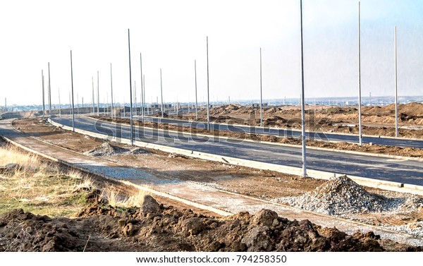 Under\
construction road in the city with lighting\
poles