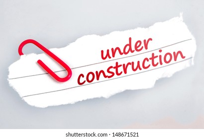 Under construction word on grey background 
