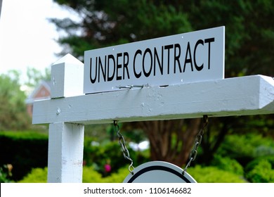 Under Contract Sign On Wooden Post. Real Estate Business.
