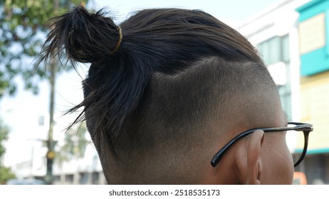 "Under cut" men's haircut with the addition of a men's bun. - Powered by Shutterstock