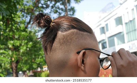 "Under cut" men's haircut with the addition of a men's bun. - Powered by Shutterstock