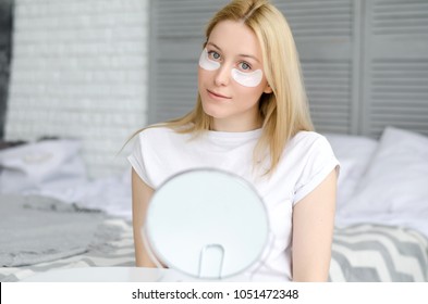 Under Eye Treatment. Woman Face With Patches Under Eyes. Beautiful Young Female With Fresh Soft Skin Applying Beauty Patches Under Eyes On Black Background. Home Interior
