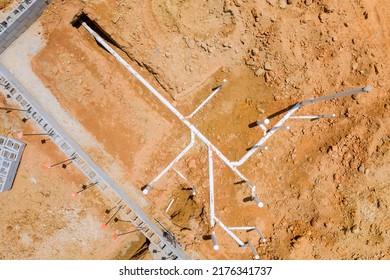 Under The Foundation Of A New Residential Construction Home, Sewer Pipes And Water Pipes Are Buried In The Ground An Aerial View