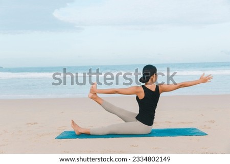 Under the golden hues of the setting sun, a woman immerses herself in a blissful yoga flow on the beach, her yoga mat grounding her practice.