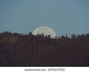 Under the moon's watchful eye, mountains stand in silent grandeur, painting a timeless tableau - Powered by Shutterstock