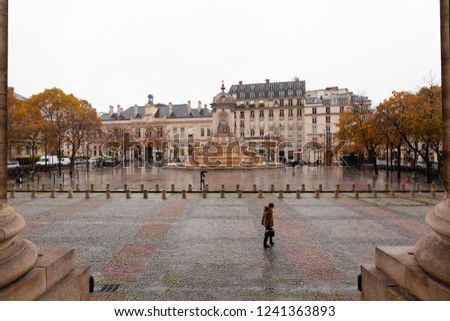 under rain , walking through the streets of Paris , place Sain Suplice