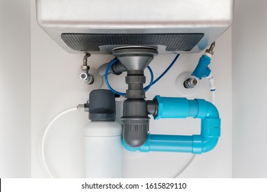 under sink plumbing and drainage system, water purification system install under modern kitchen sink, shallow depth of field