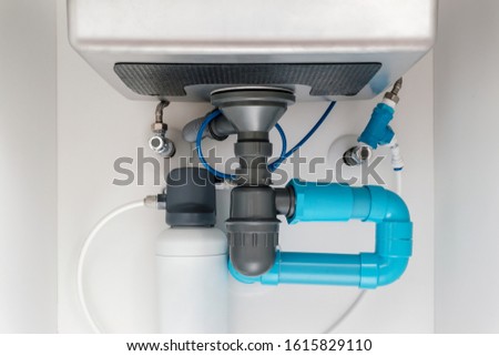 under sink plumbing and drainage system, water purification system install under modern kitchen sink, shallow depth of field
