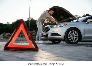 Under the sunlight, red sign, accident, broken automobile, repair. Man is with his car outdoors. - Powered by Shutterstock