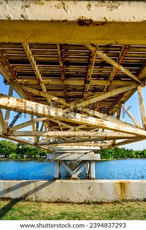 Under suspension bridge with lake in public park, Nahkon Sawan province.